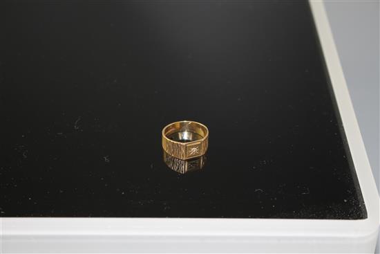 A modern 9ct gold and diamond chip set signet ring, with textured shoulders, size R/S, gross 3.9 grams.